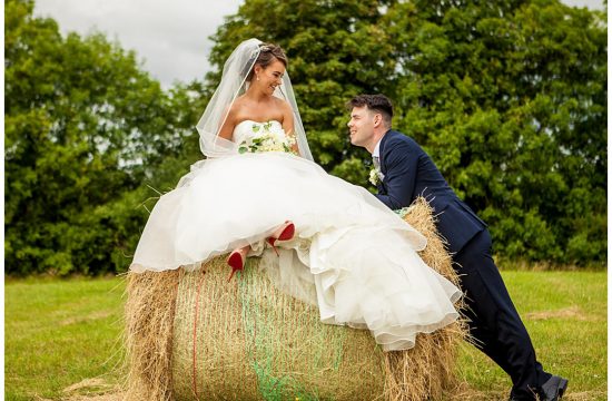Bride sitting on a bale of hay
