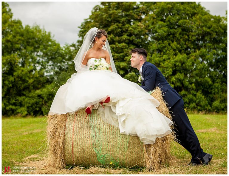 Bride sitting on a bale of hay